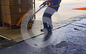 Worker loading and unloading shipment carton boxes and goods on wooden pallet by forklift  from container truck to warehouse cargo