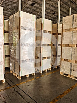 Worker loading and unloading shipment carton boxes and goods on wooden pallet by forklift from container truck to warehouse cargo