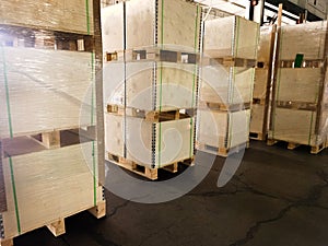 Worker loading and unloading shipment carton boxes and goods on wooden pallet by forklift from container truck to warehouse cargo