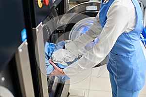 The worker loads the Laundry clothing into the washing machine