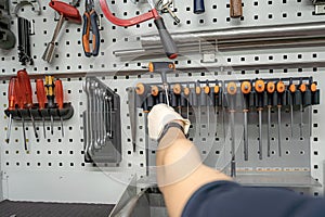 A worker in a locksmith workshop selects a screwdriver for work