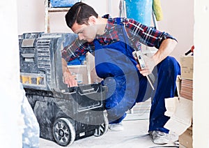 Worker looking for necessary tool in toolbox