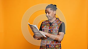 Worker looking over paperwork graphs, studio background