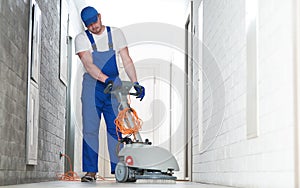 worker with machine cleaning floor in residence hall