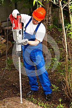 Worker with a machine drill