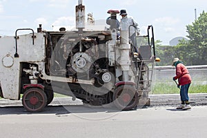 Worker and machine working on road construction