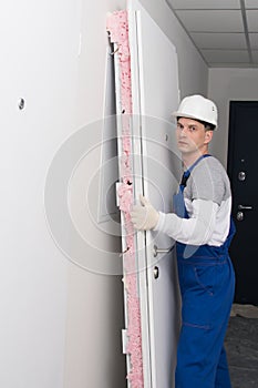 Worker made dismantling of the old door, side view