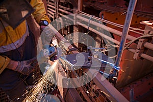 Worker maintenance using a silver G-clamp device holding metal workpiece, wearing a glove hand protection