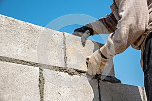 Worker make concrete wall by cement block and plaster at constru