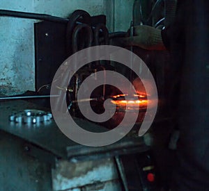 The worker makes hardening heat treatment of the metal gear on a special machine, close-up, hardening of metal, hardening