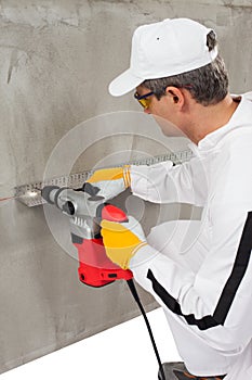 Worker making a hole through a lath