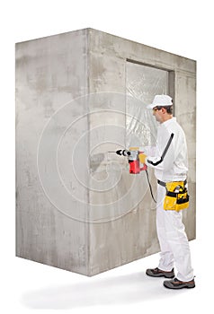 Worker making a hole with a perforator in cement wall