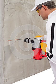 Worker making a hole with a perforator