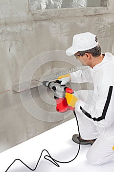 Worker making a hole trough a lath