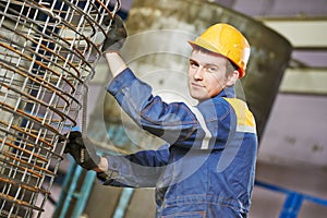 Worker making reinforcement for pipe