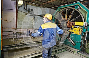Worker making reinforcement for pipe
