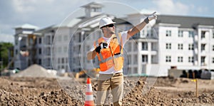 Worker man on the building construction. Construction site worker in helmet work outdoors. Builder worker working on