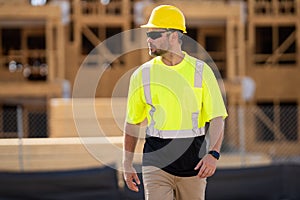 Worker man on the building construction. Construction site worker in helmet work outdoors. Builder worker working on