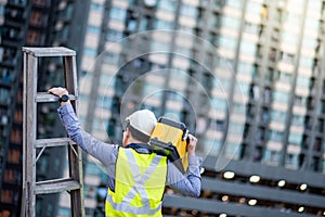 Worker man carrying aluminium ladder and tool box