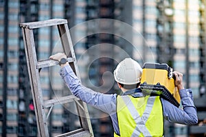 Worker man carrying aluminium ladder and tool box