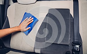 Worker man cleaning dust interior by cloth microfiber inside car