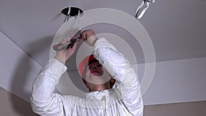 Worker man climb up on ladder and remove insulation from wires for lighting