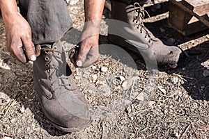 Worker man closing her shoes.