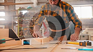 Worker man cutting the wood using a circular saw in the workshop