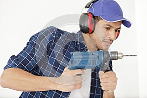 worker man drilling in concrete on construction site