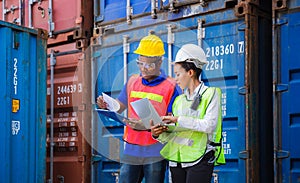 Worker man in hardhat and safety vest holding clipboard checklist and Female foreman using laptop control loading containers box