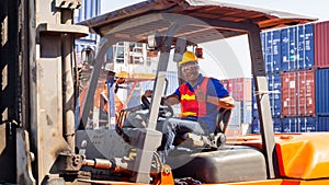 Worker man in hardhat and safety vest sitting in container stackers smiling with giving thumbs up as sign of Success