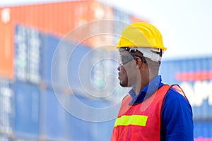 Worker man in hardhat and safety vest standing at containers cargo, Foreman control loading containers box from cargo