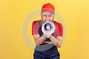 Worker man holding megaphone near mouth loudly speaking, screaming, making announcement.