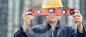 Worker man holding red aluminium spirit level tool