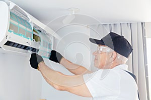 Worker man instal ac conditioner from home or office, maintenance of air conditioning units photo