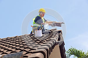 Lavoratore uomo riparazione grondaia un piastrelle da vecchio tetto 