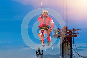 Worker man sprinkle of high and worker on scaffolding with harness concept.