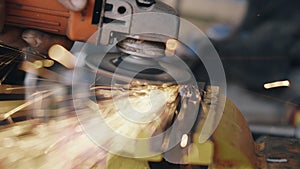 Worker man using electric wheel tool grinding and cutting on steel structure