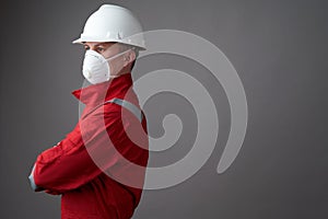 Worker man wearing hygienic mask, overall and protective hard hat