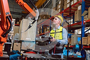 Worker man working with robot arm automate welding machine in modern metal factory. Engineer program robotic in heavy industry