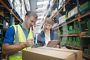 Worker and manager scanning package in warehouse