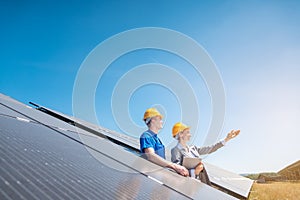 Worker and manager of solar farm looking into the sun