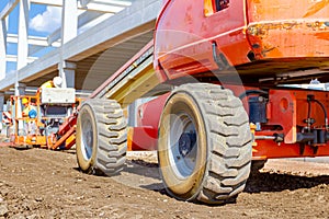 Worker is managing a cherry picker at building site