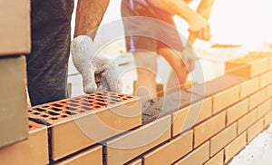 Worker or mason hands laying bricks close up. Bricklayer works at brick row. Brickwork on construction site