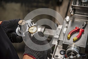 The worker measure the shaft dimension by the dial vernier calliper.