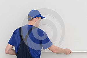 Worker measures the curvature of the wall with a