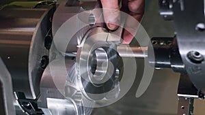 Worker measures by professional tool in lathe