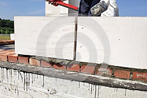 The worker measures the work out wall with a level.