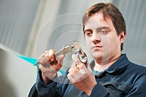 Worker measuring detail with caliper
