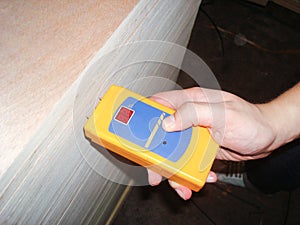 Worker Measuring the Level of Wood Moisture Densit